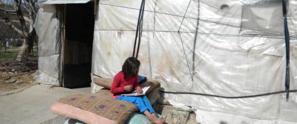 el regreso aún no es posible Una niña de nuestro centro haciendo su tarea fuera la tienda