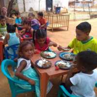 en el patio de un iglesia dan de comer a niños pobres